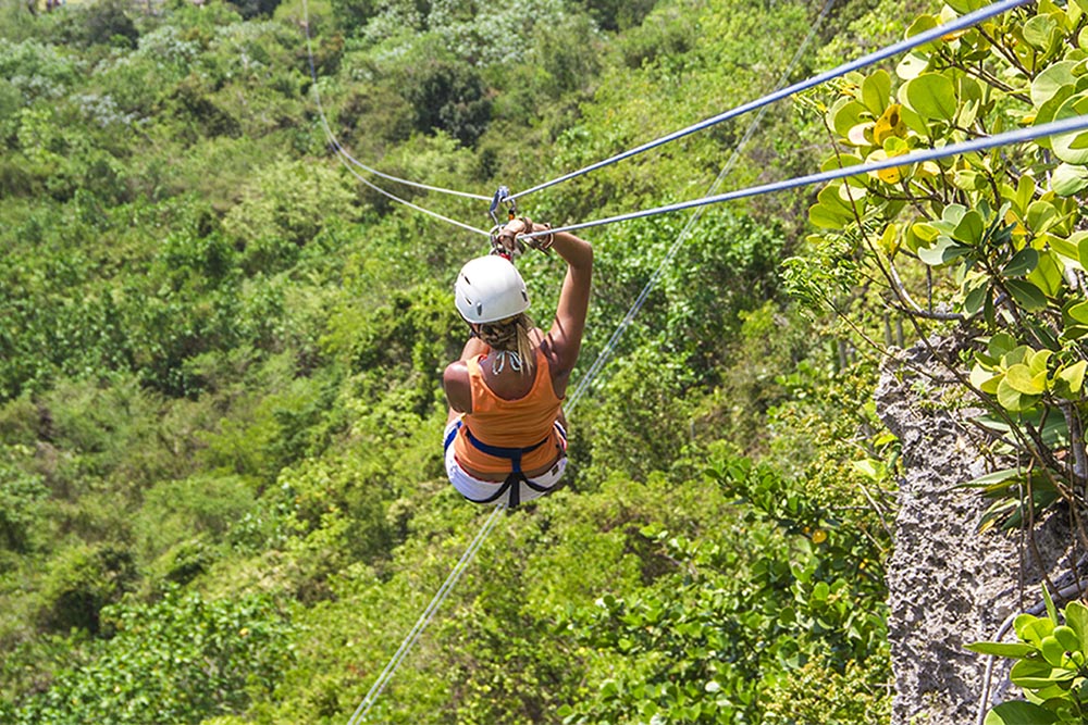 Woman zip lining through the jungle