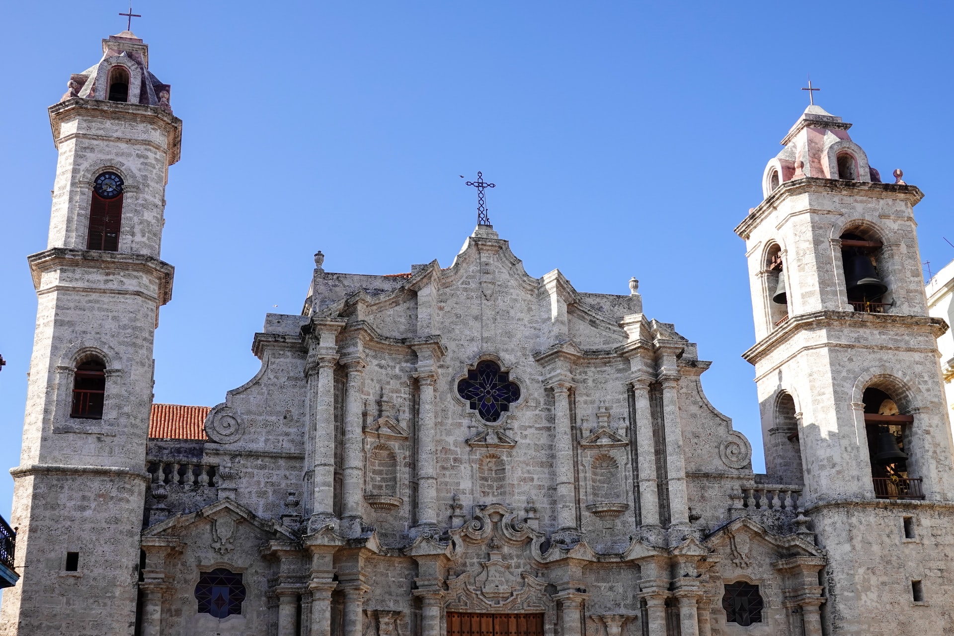 Looking up at a large catholic building with a background of blue sky