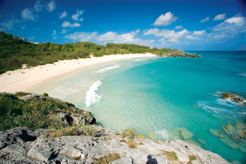 Pristine beach with turquoise waters view over a rock