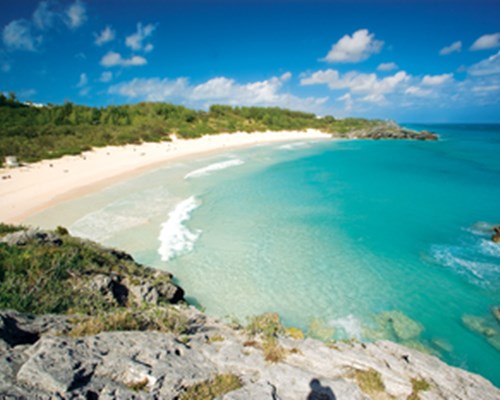 Pristine beach with turquoise waters view over a rock