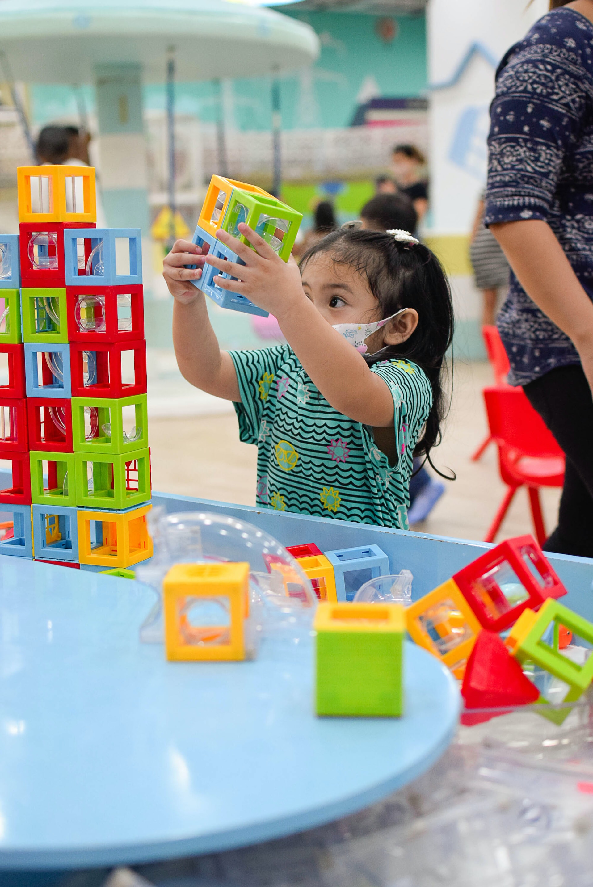 A little girl playing with building blocks