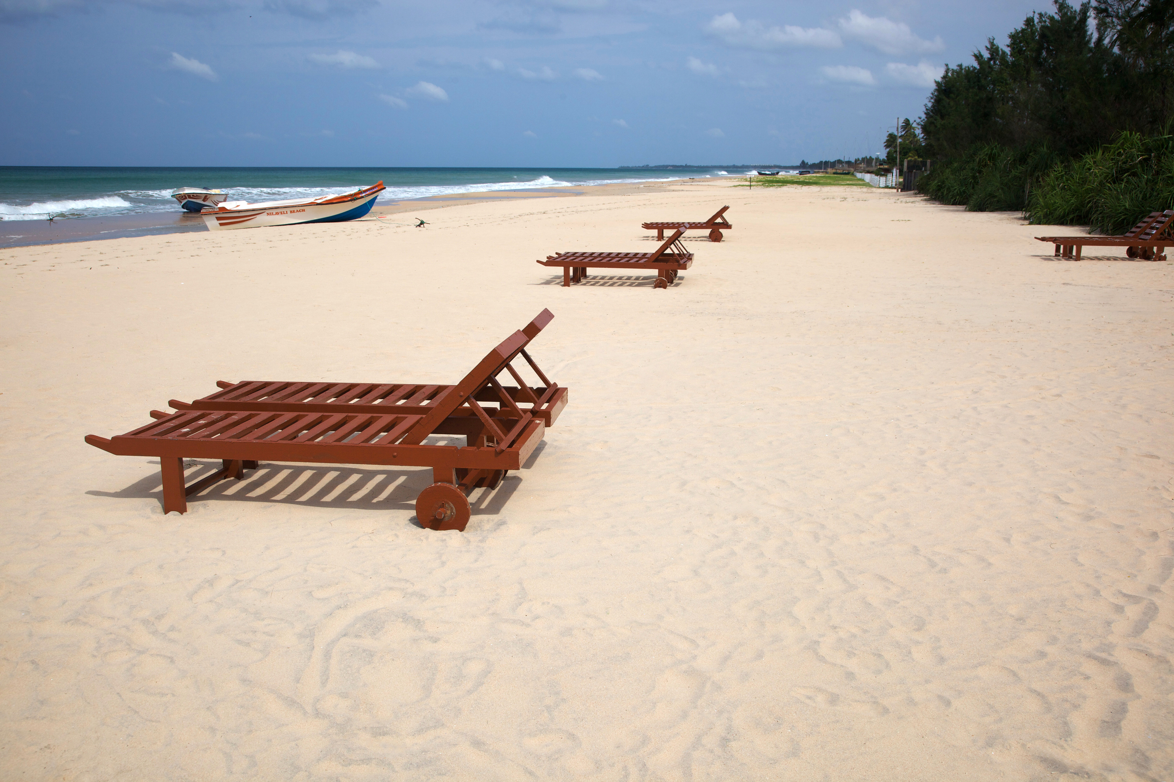 Wooden sun loungers on a white sand beach