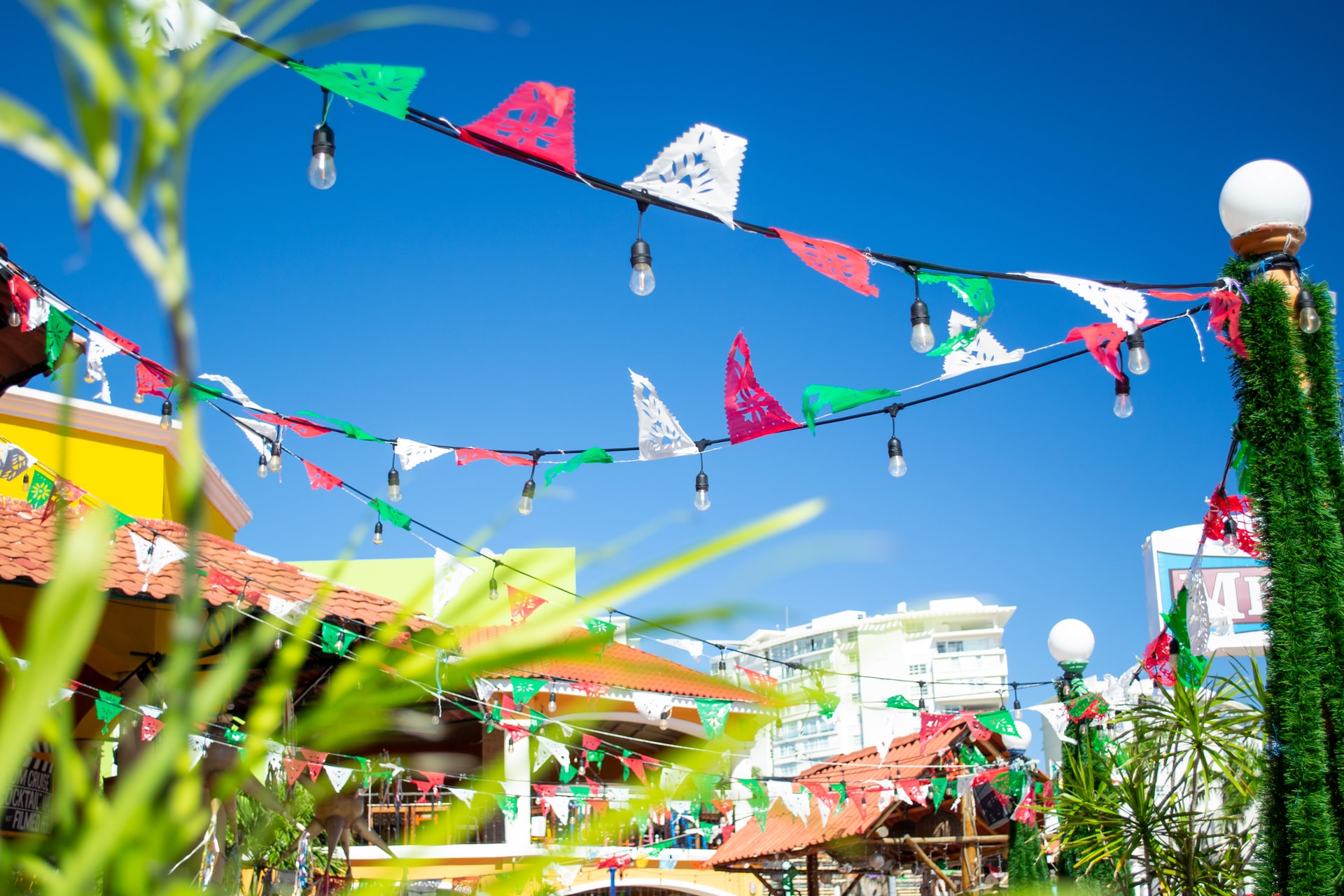 Decorative flag bunting hung across yellow buildings with terracotta roofs