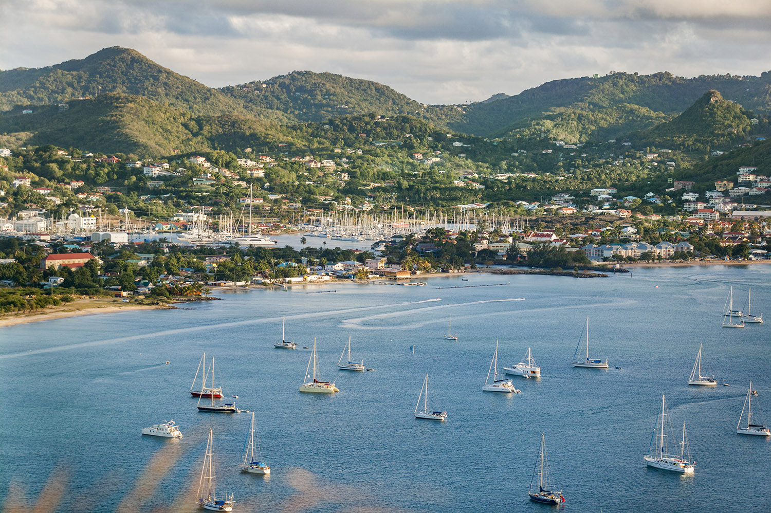 Sailing yachts anchored in bay of a mountainous tropical island