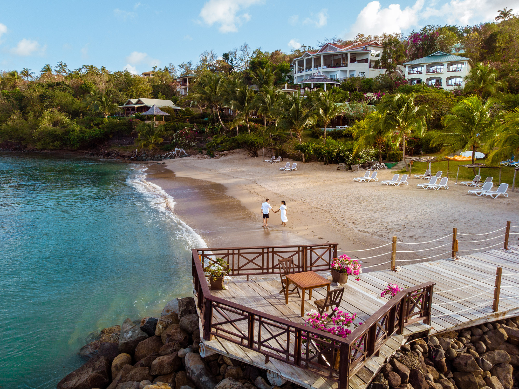 Couple on holiday walking along a beach at the tropical island of St Lucia