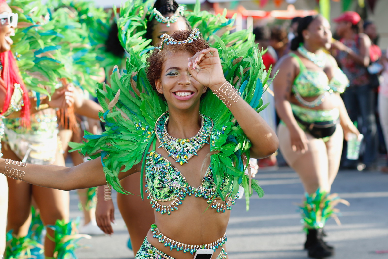 Woman in green carnival outfit dancing in parade