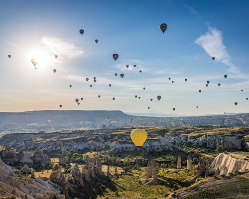 Hot air balloons in the clear blue sky over beautiful landscapes