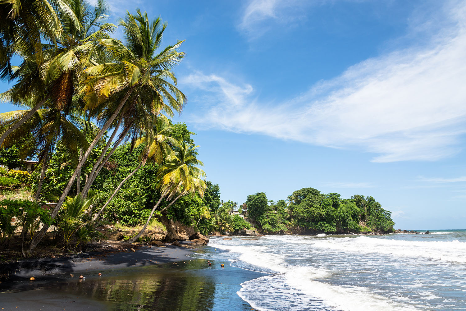 Waves crashing on a black sand tropical beach