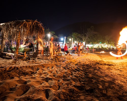 Fire performers at a beach party at night on a tropical beach
