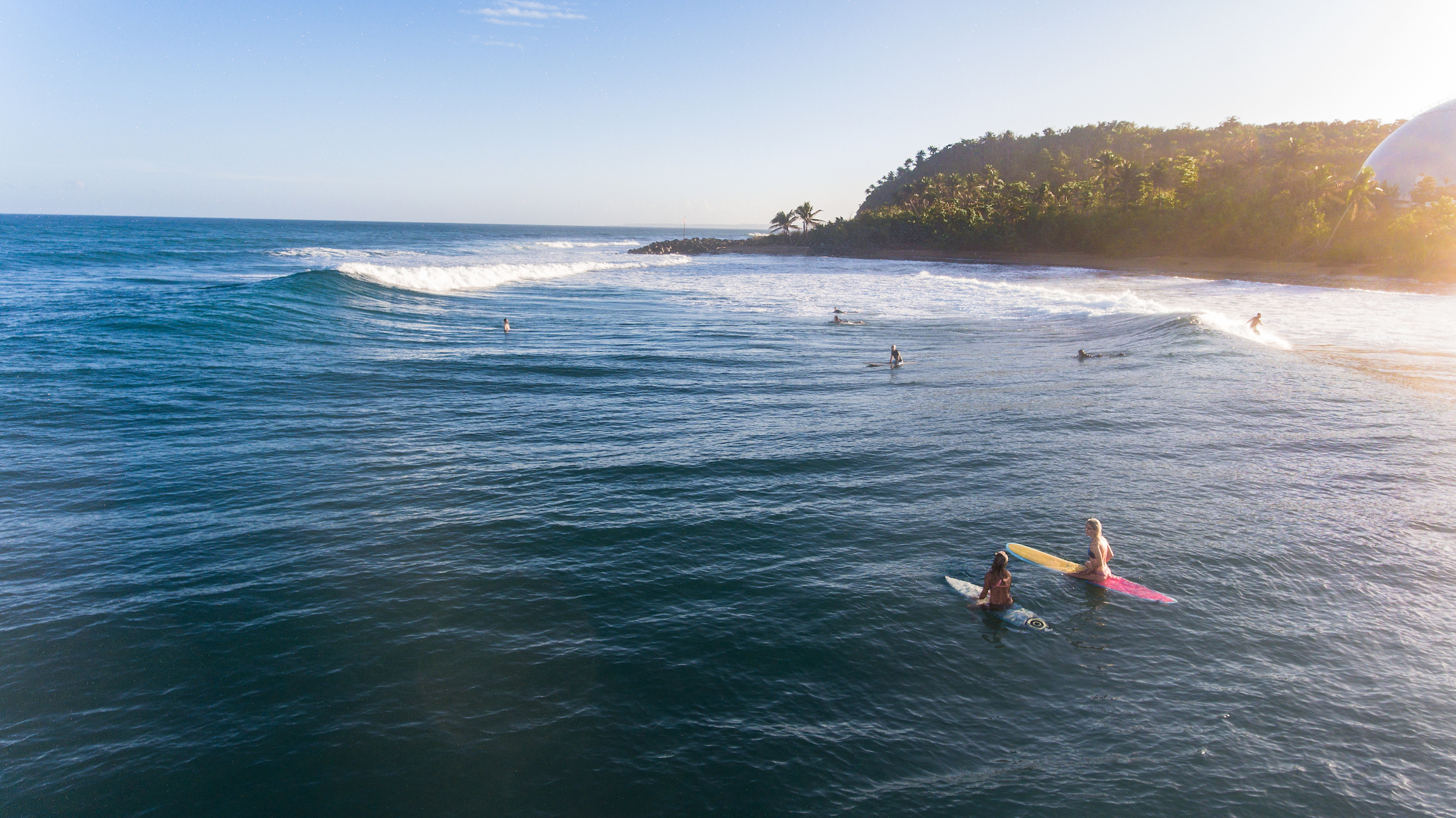 Sapphire sea with wild waves and jungle dome in background