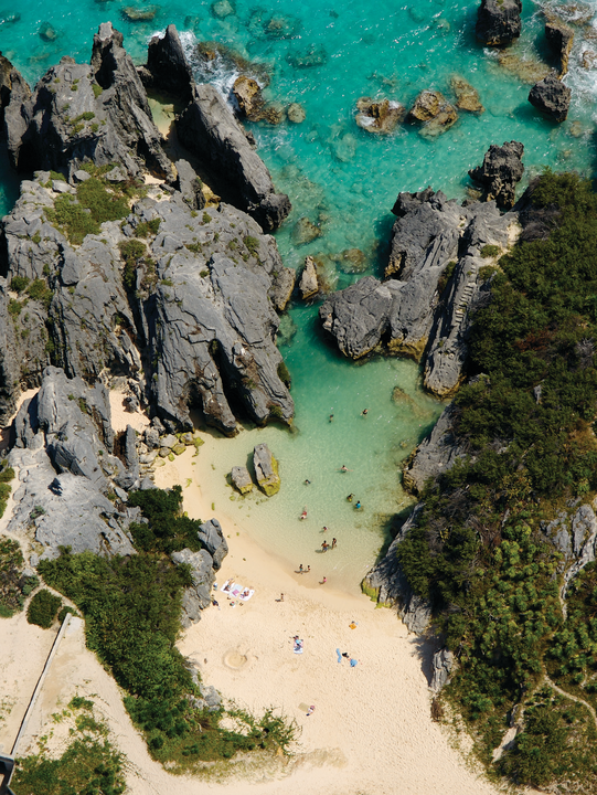 Aerial view of white sandy beach with turquoise waters and rocks
