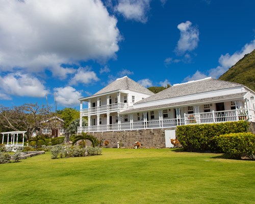 Large manor house surround by tidy tropical gardens