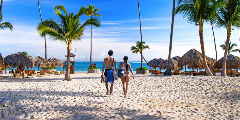 Couple walking across white sand Bavaro Beach in Punta Cana, Dominican Republic