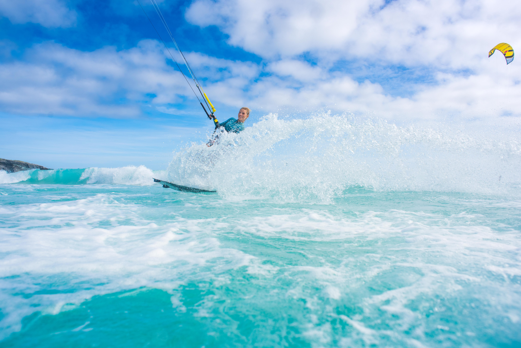 Woman kite surfing on foamy waves in the sea