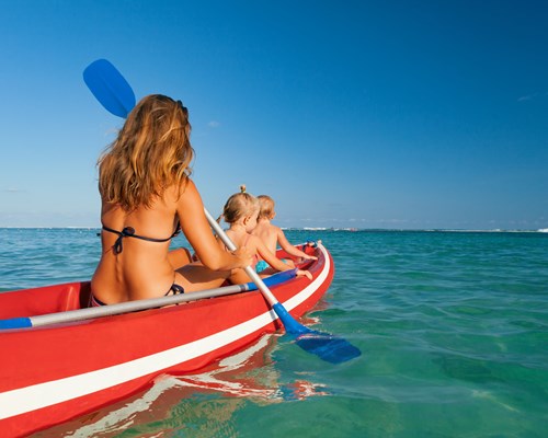 Mother and two young kids paddling in a kayak
