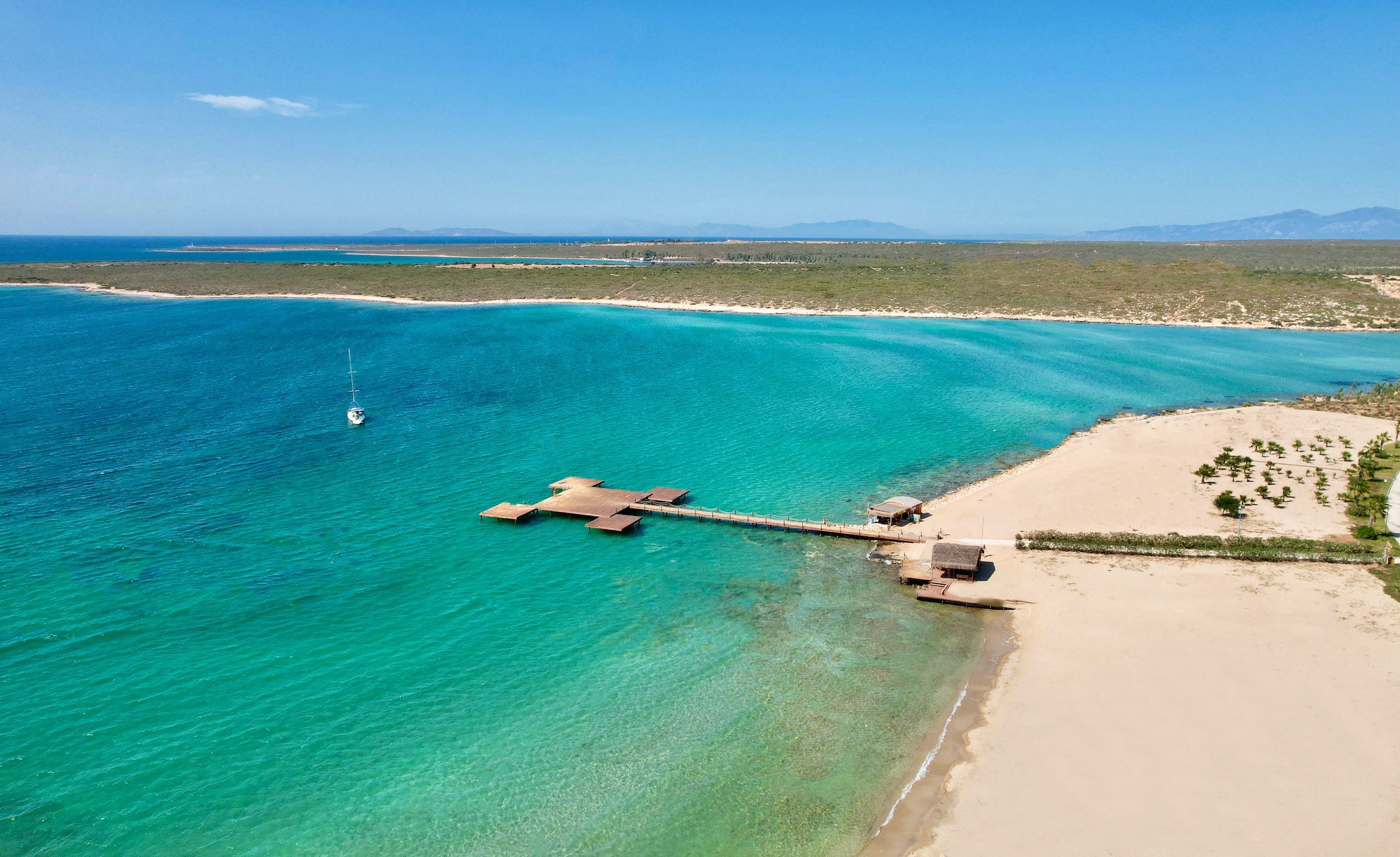 A wooden pathway leading onto a pristine sea