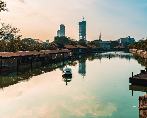Lake with city skyline in background at sunset