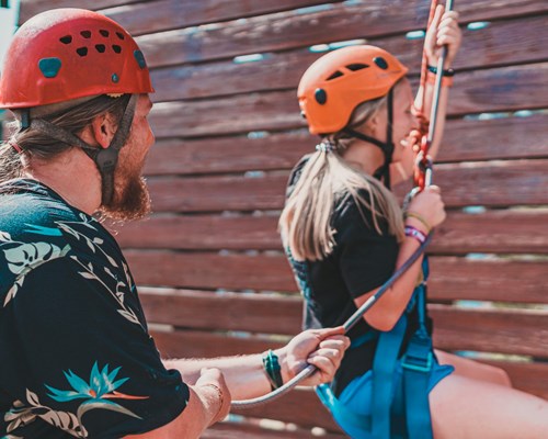 Instructor teaching a woman to use climbing ropes