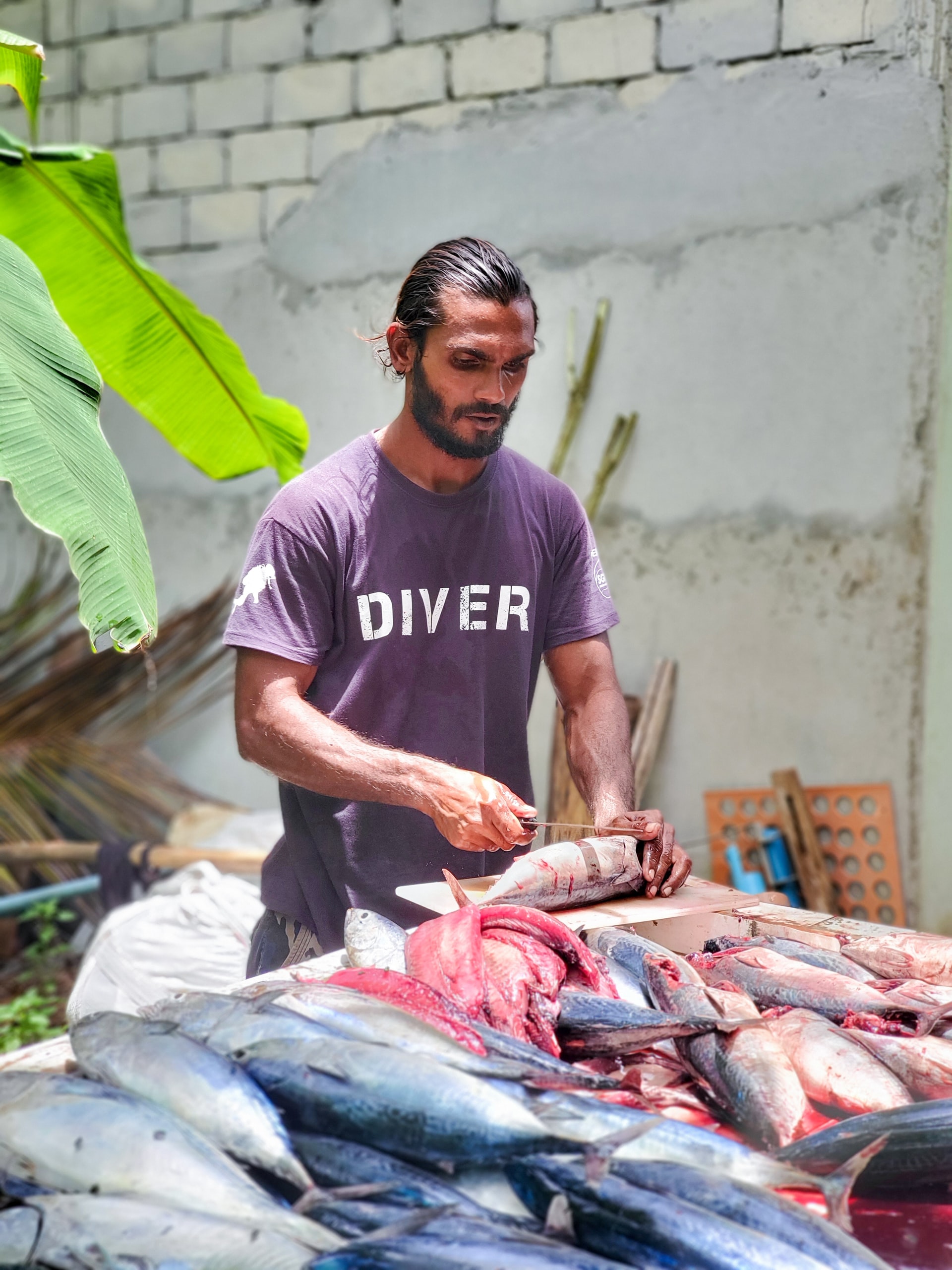 A man cutting fish at a market stall