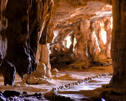 Brown rock formations in a dark cave