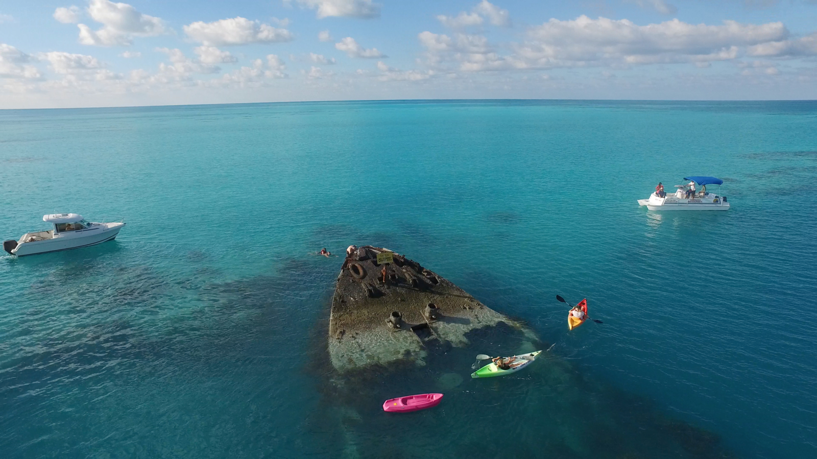 Kayaking over a shipwreck in a clear blue sea