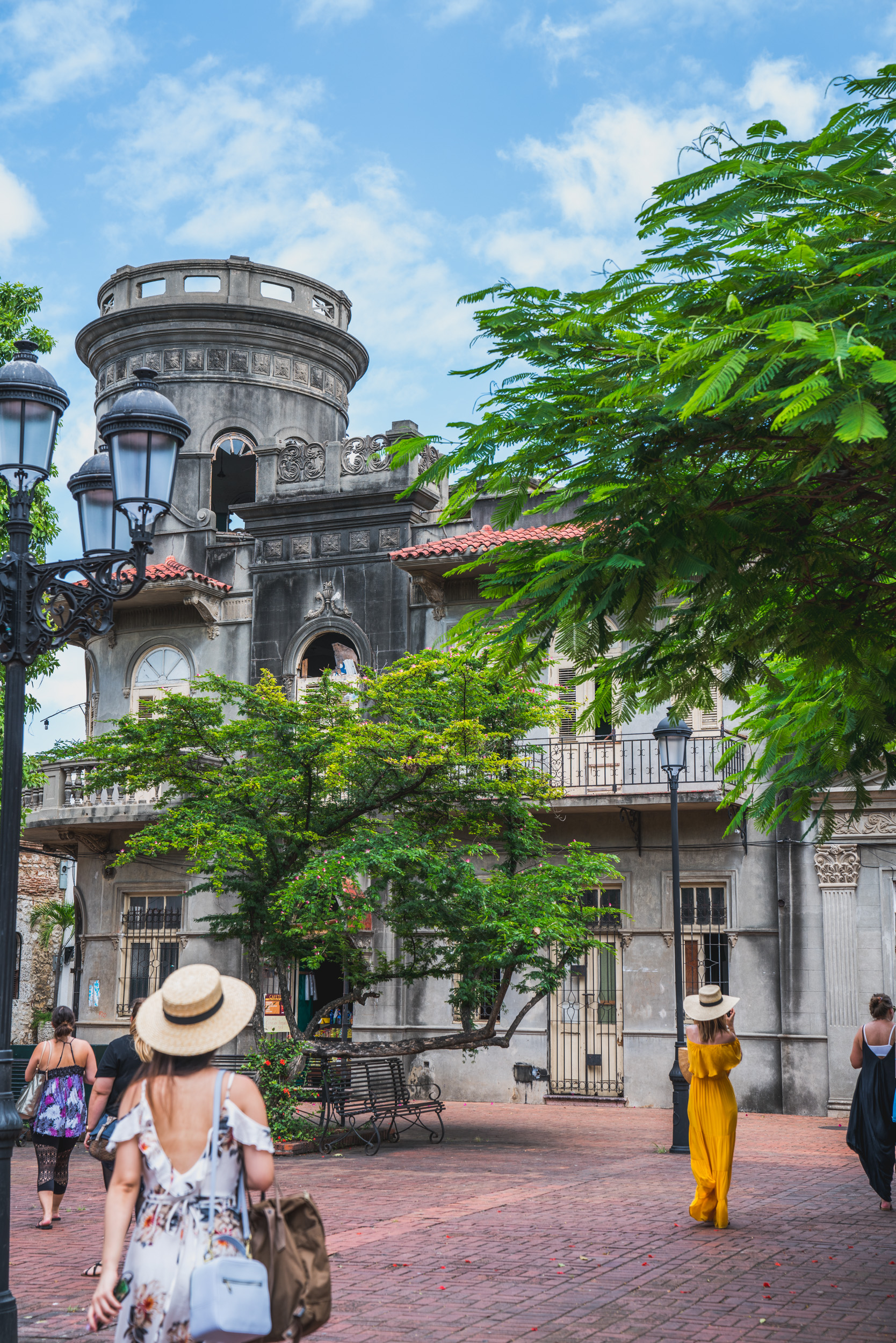 People walking around a town square with tall historical buildings