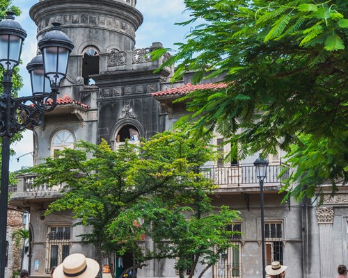 People walking around a town square with tall historical buildings