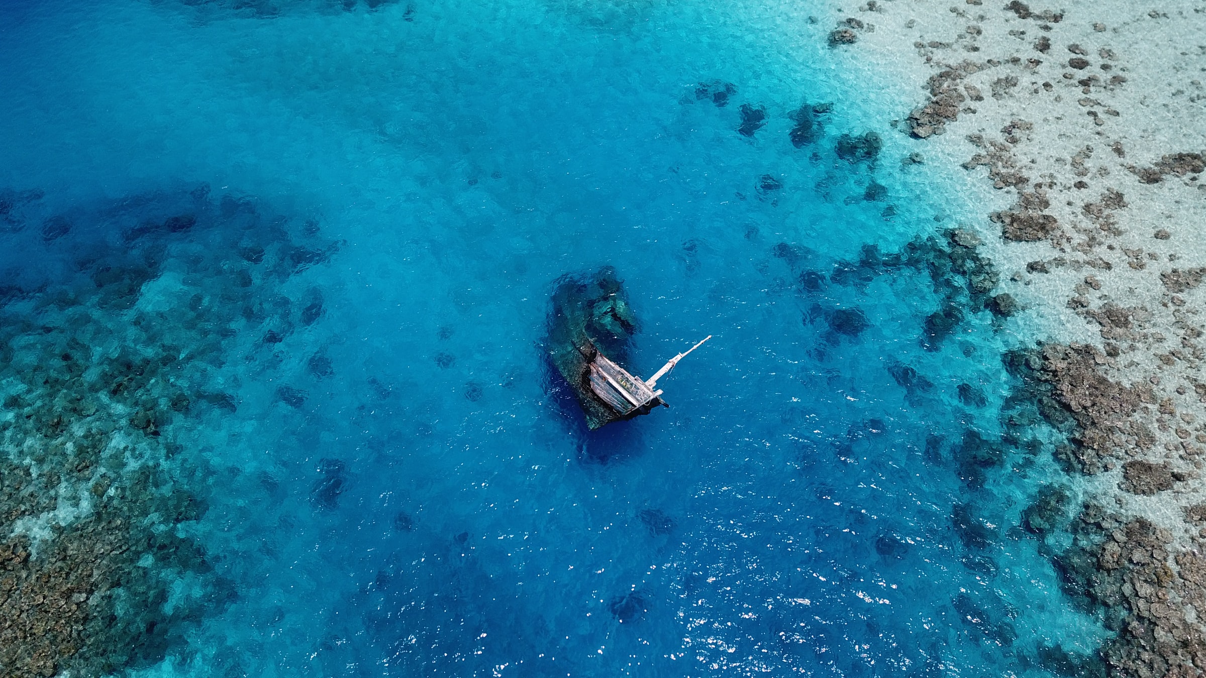 Shipwreck submerged into the ocean surrounded by corals