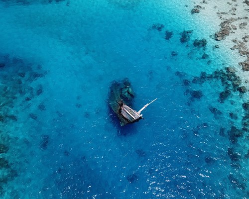 Shipwreck submerged into the ocean surrounded by corals