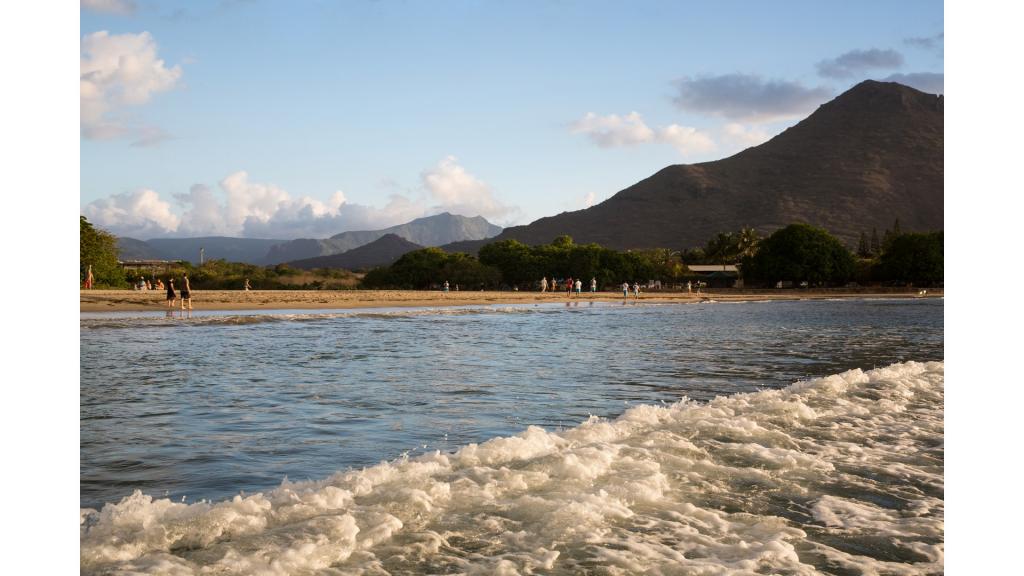 Landscape photo of mountains in the background of a beige beach