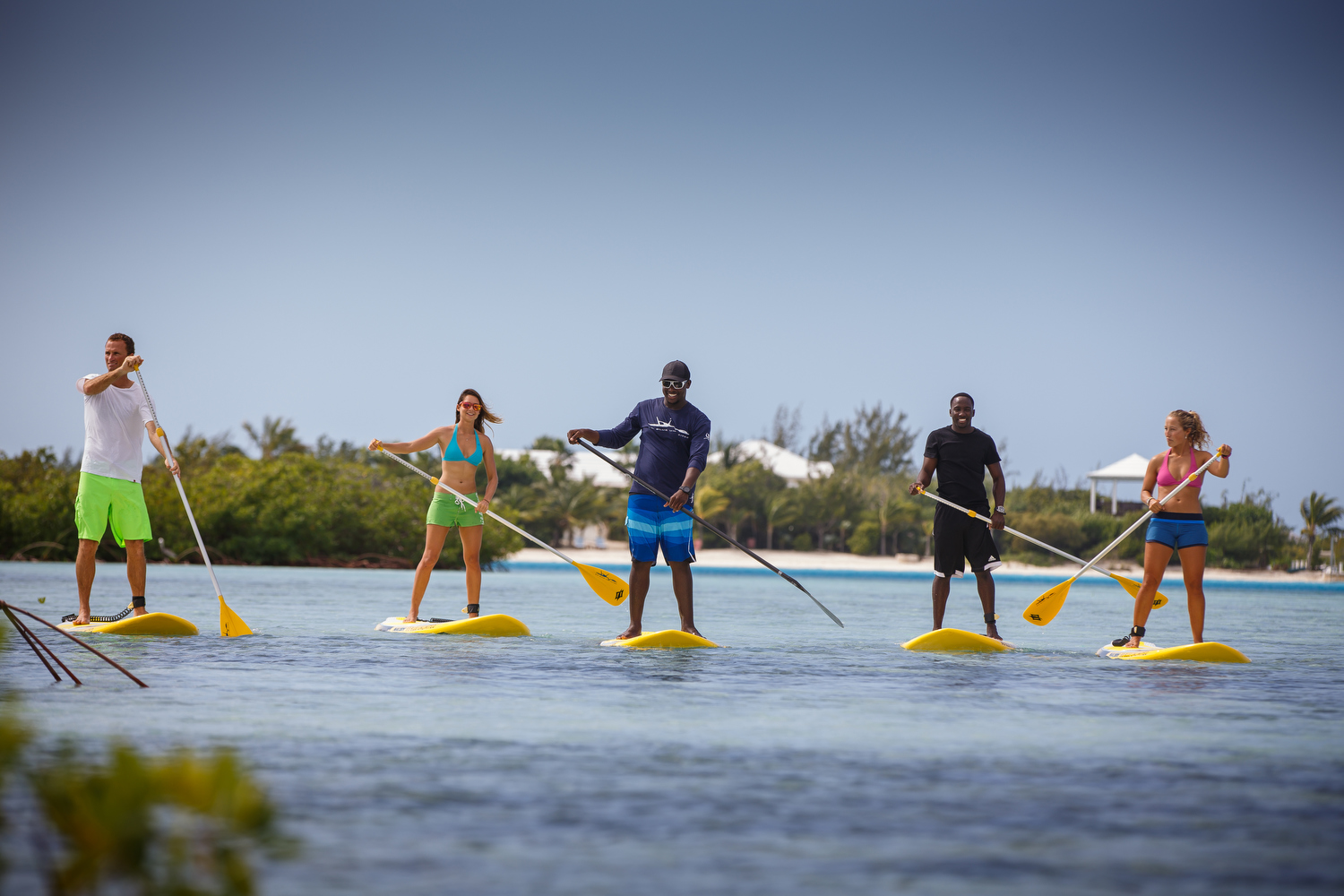 group of friends on stand up paddle boards