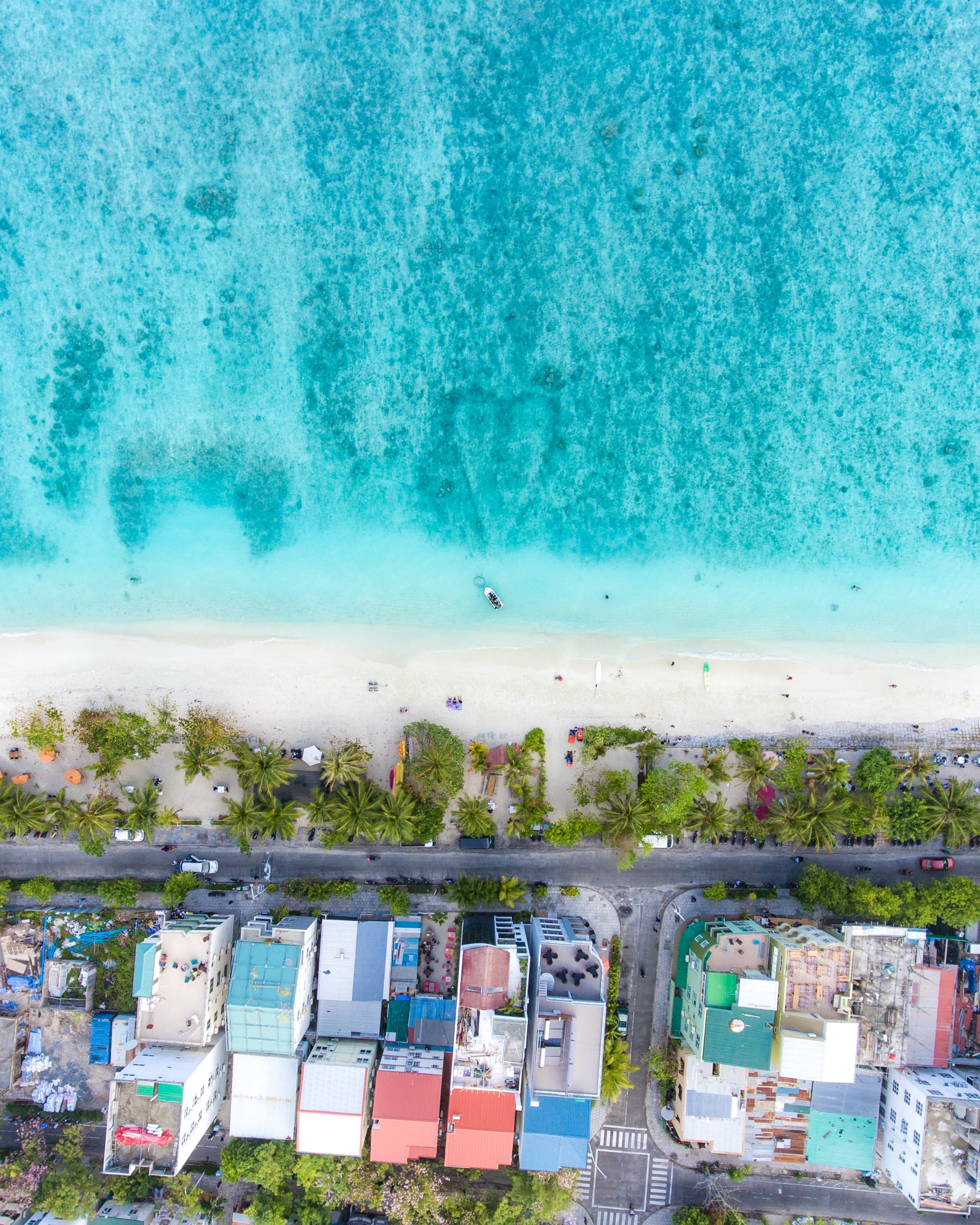 Aerial view of a diamond blue beach edging colourful town