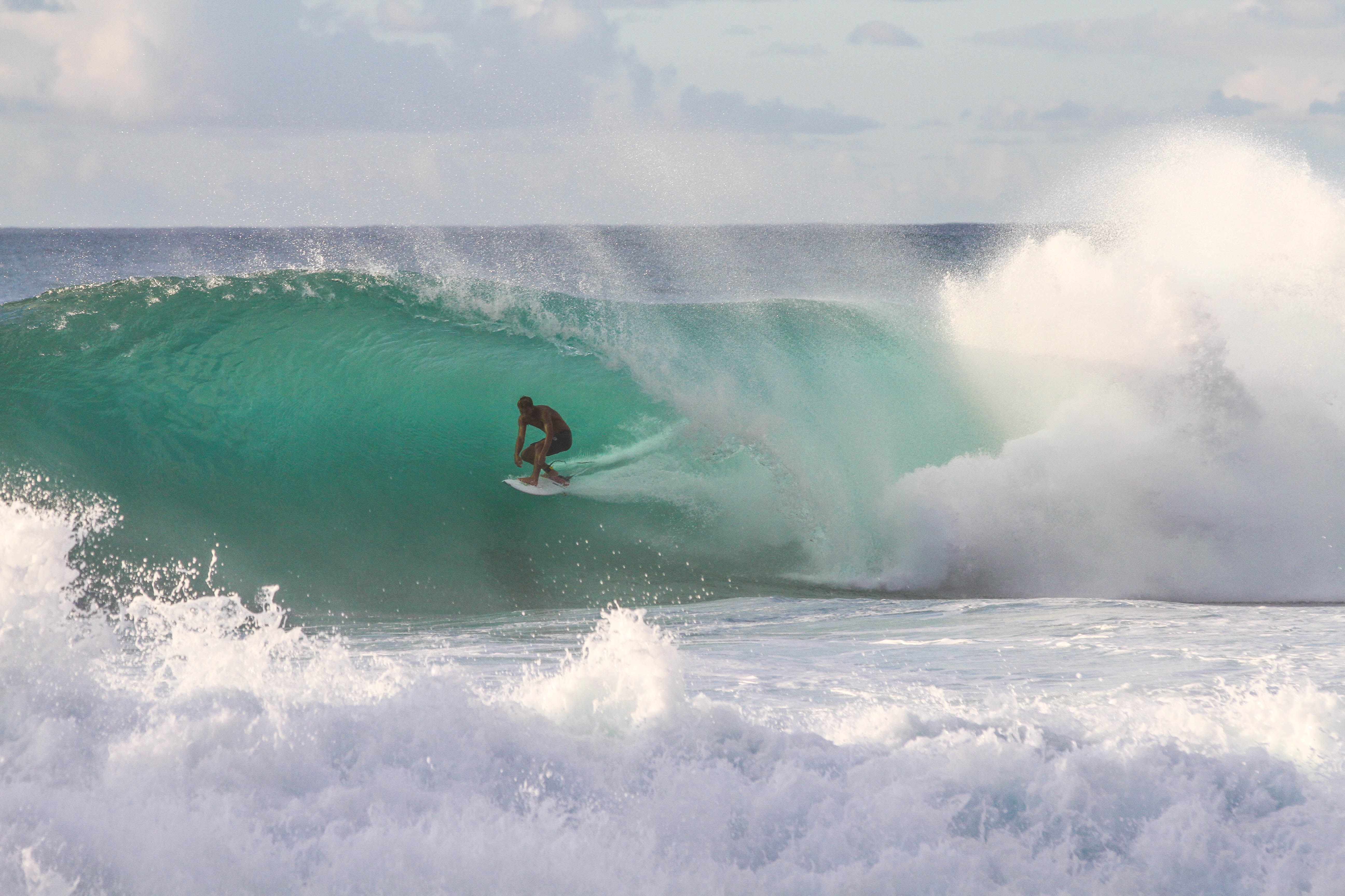 A man surfing on huge waves