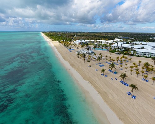Stretch of white sand beach next to a large hotel resort in the Bahamas