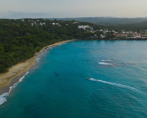 Aerial view of  a tropical beach with golden sand and bright blue sea