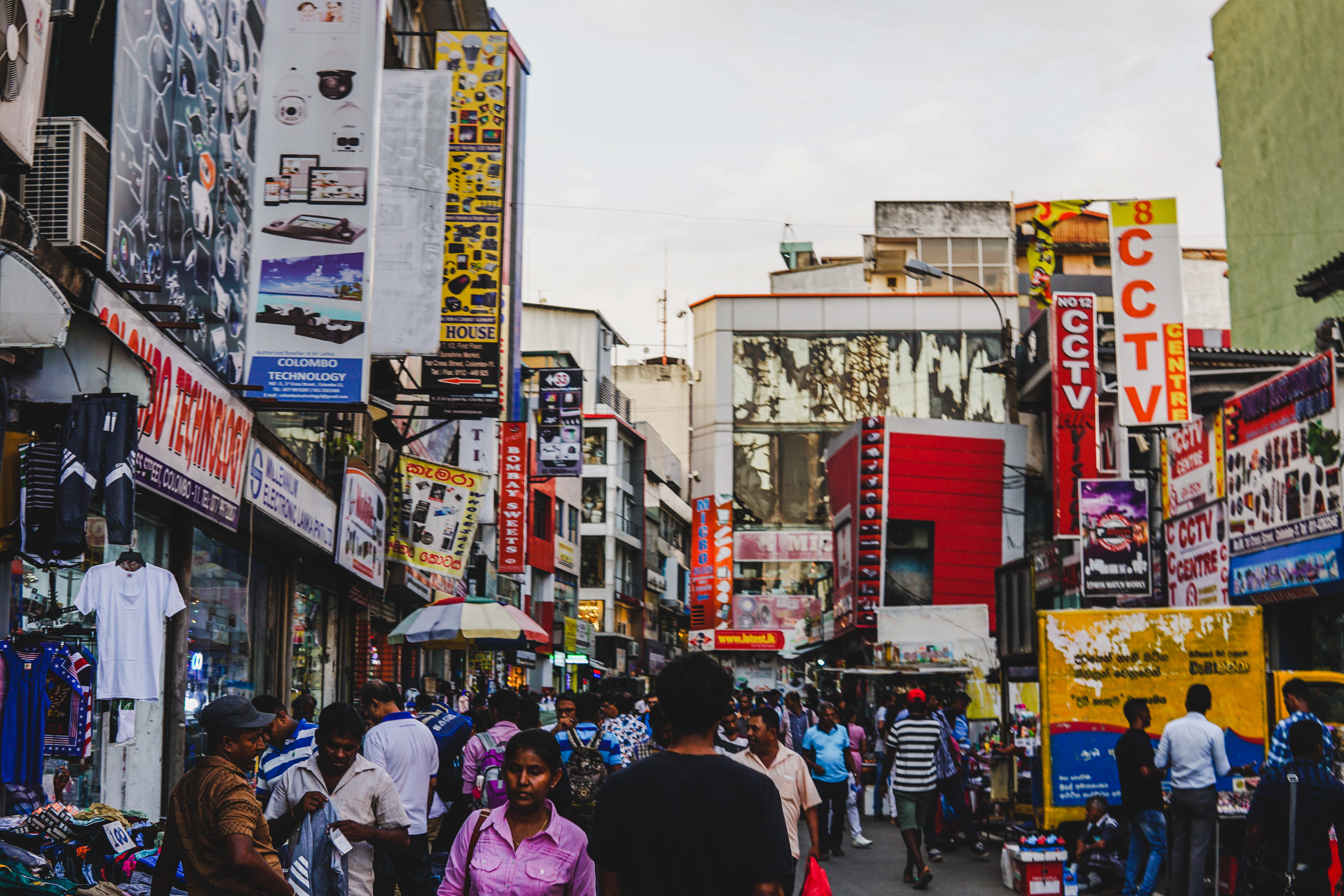 Busy market street with colourful signs and crowds of people