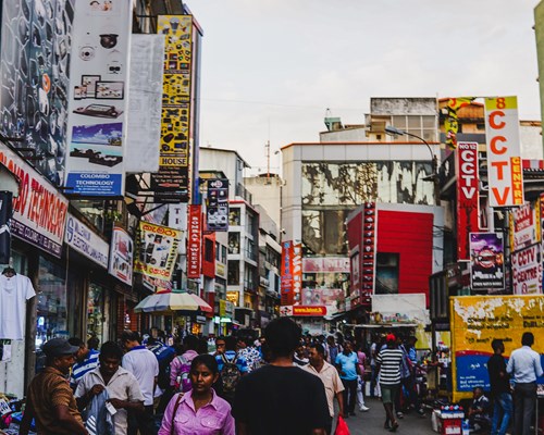 Busy market street with colourful signs and crowds of people