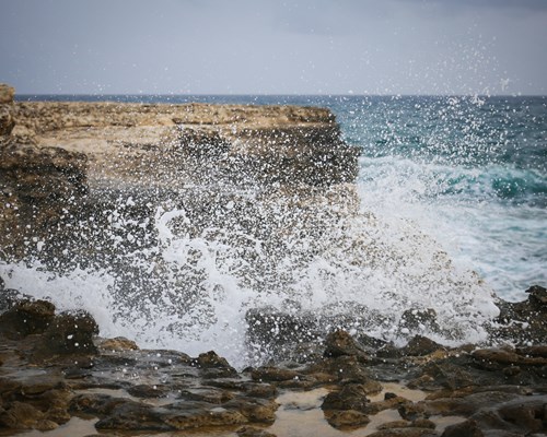 Waves crashing into a cliff at Devil's Bridge