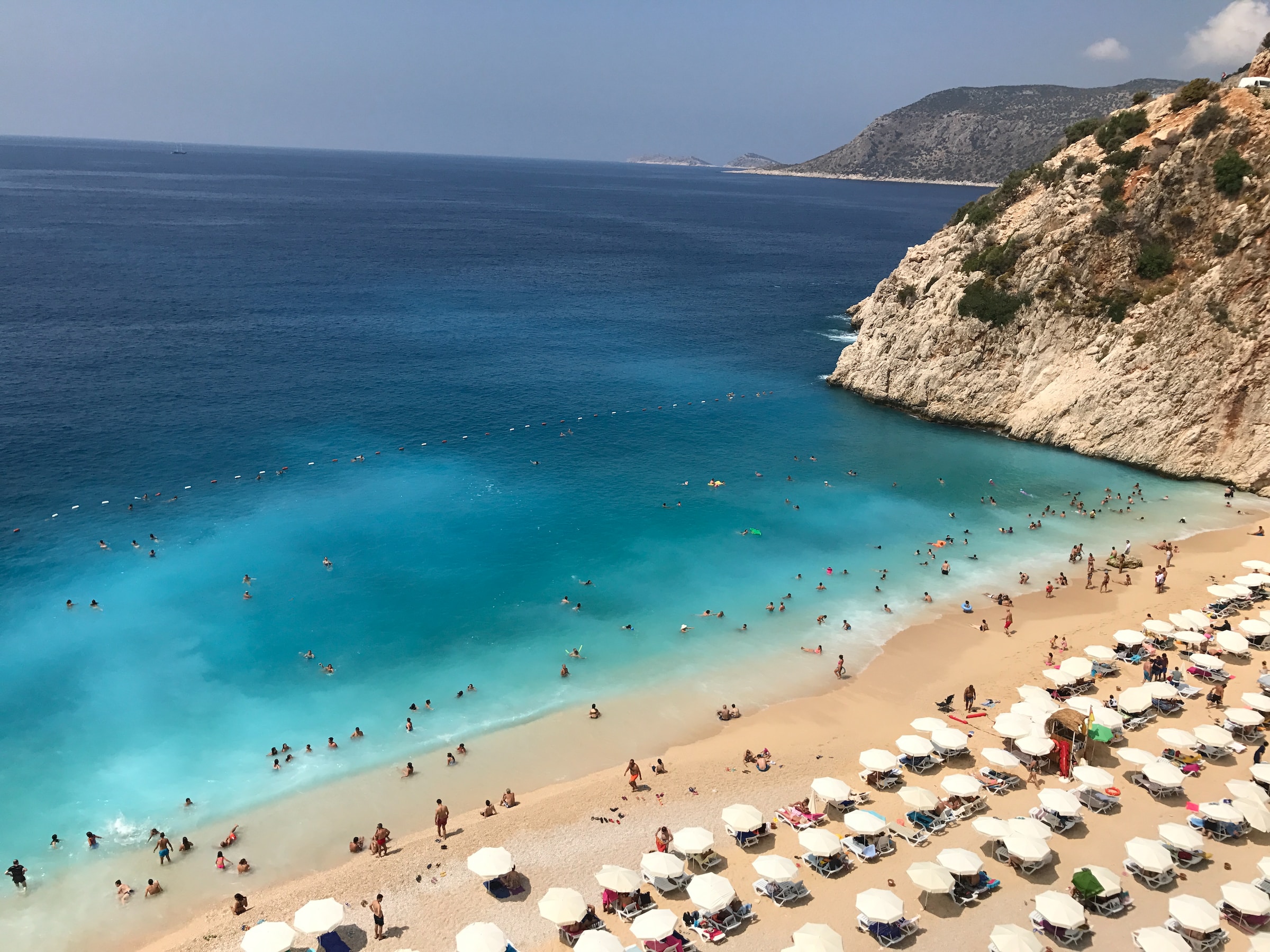 A deep-blue beach fringed by umbrellas