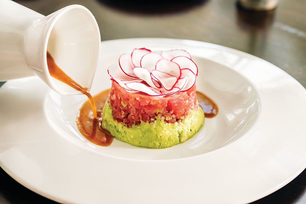 Colourful fresh fish dish presented beautifully on large white plate
